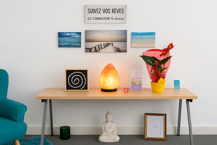 Décoration intérieure du cabinet avec lampe de sel, bouddha, plante rouge et citation inspirante sur le mur