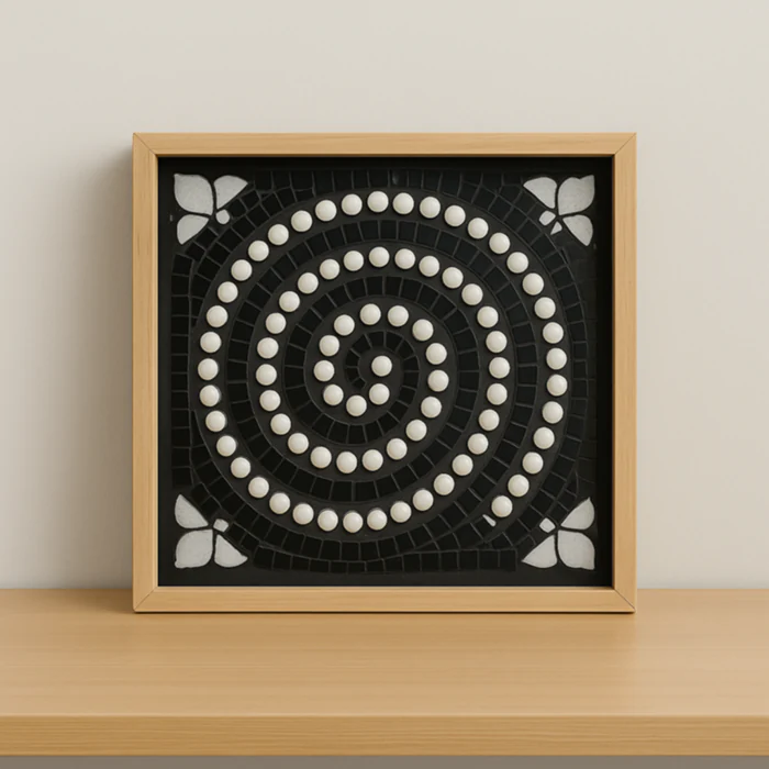 Cadre décoratif avec spirale noire et blanche en billes, évoquant l’hypnose, sur une étagère en bois clair